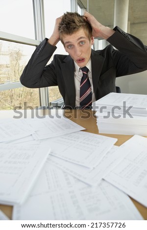 Businessman sitting with documents and looking worried