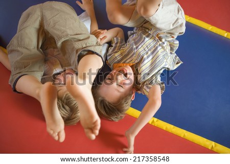 High angle view of two boys playing on an inflatable bouncy castle