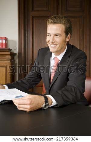 Happy businessman sitting at table