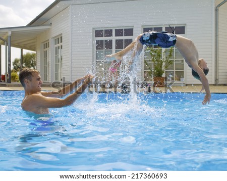 Boy doing back flip in pool