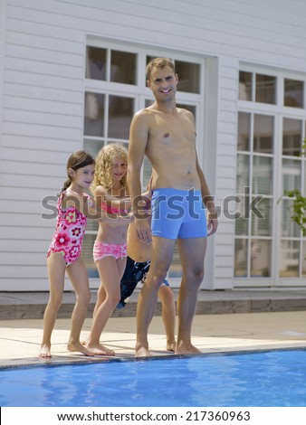 Children pushing man in pool