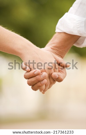 Close-up of a man and a woman holding each other\'s hands