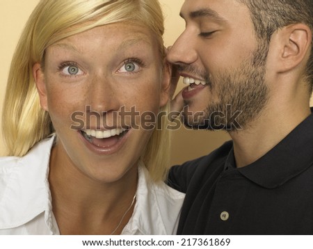 Man whispering in woman\'s ear