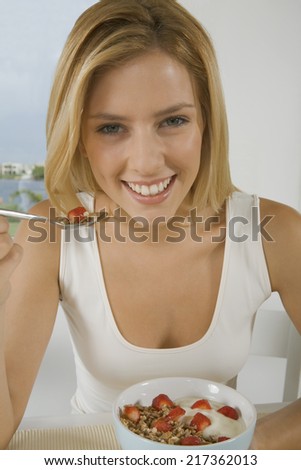 Happy woman eating cereal