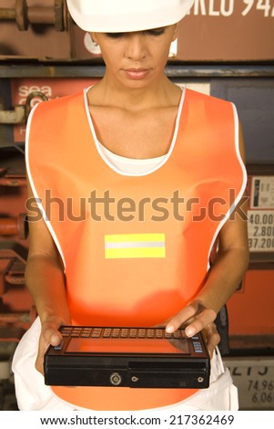 Close-up of a female dock worker using a handheld device