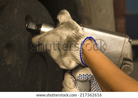 Close-up of a woman\'s hand tightening the bolt of a tire