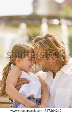 Young man playing with his daughter and smiling
