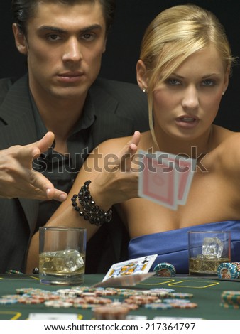 Couple throwing playing cards at poker game
