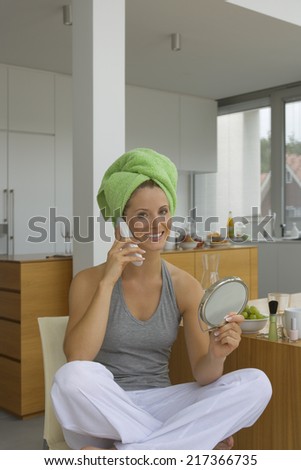Woman with phone and hand mirror