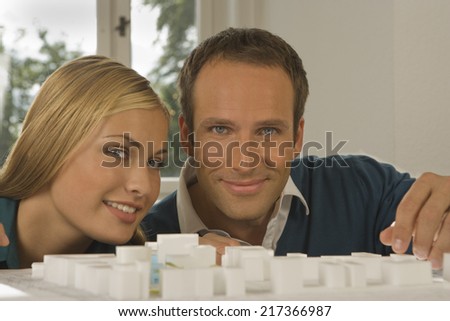 Portrait of two architects smiling in front of an architectural model