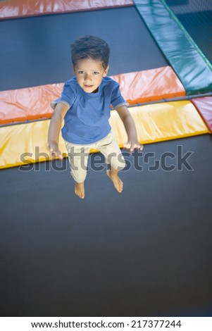 High angle view of a boy jumping on a trampoline