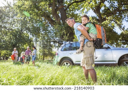 Multi-Generation Family Unpacking Car On Camping Trip