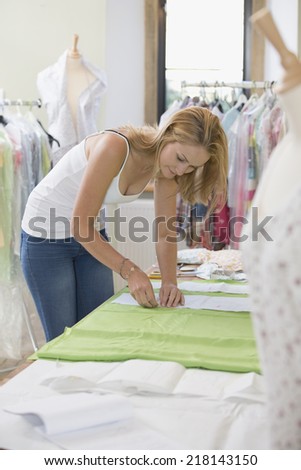 Fashion Designer Sewing Fabric In Studio