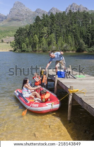 Family Getting Into Inflatable Boat For Fishing Trip