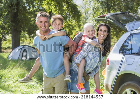 Family Flying Kite Camping Holiday In Countryside