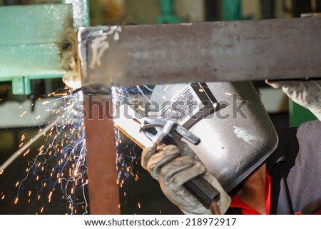 worker welding steel construction by electric welding