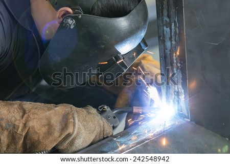 operator welding steel construction by MIG welding machine