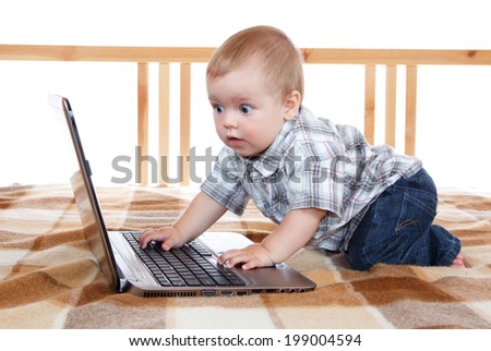 Wondered baby looks at notebook screen