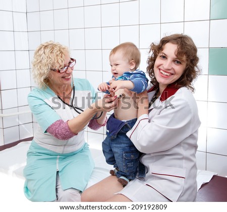Female doctor and nurse examine little angry baby