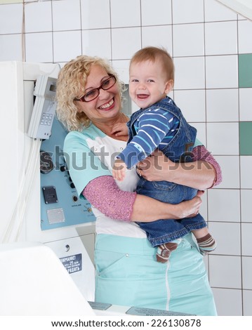 Smiling female doctor with little baby on her hands in hospital