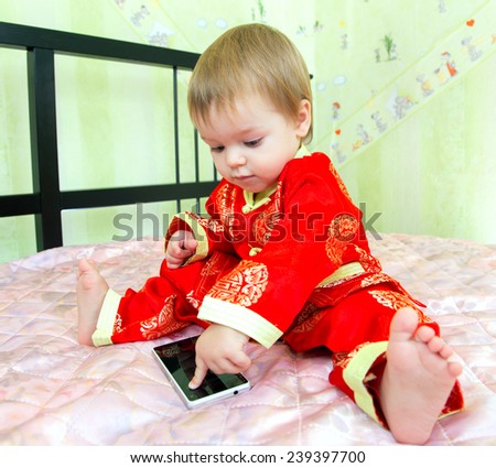 Little boy in holiday suit touches telephone screen