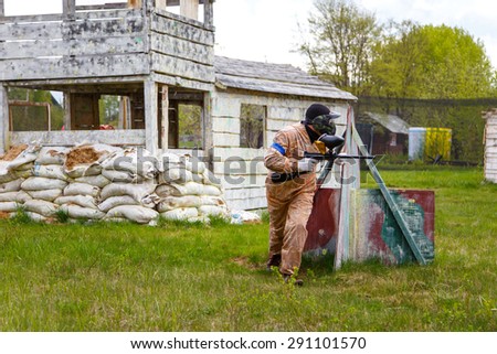 Paintball warrior with paint gun and fortress behind