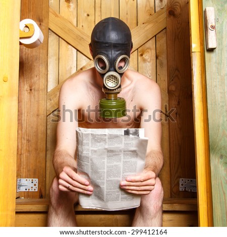 Nude man in gas-mask sitting in stinky toilet in Finland