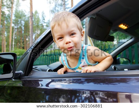 Funny small kid looking from open car window