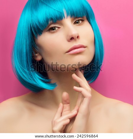 isolated studio portrait of a beautiful girl with turquoise hair on pink background