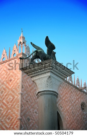 Venezia symbol: Winged lion column in front of Palazzo Ducale (Doge\'s Palace) near San Marco Basilica, at sunset (Venice, Italy)