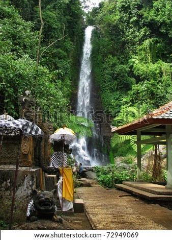 Bali: impressive Gitgit waterfalls, surrounded by beautiful wild nature and a lovely temple. Near Lovina, north Bali (Indonesia)
