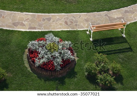 View from a terrace hotel on a park path,  bench, flowerbed and green lawn