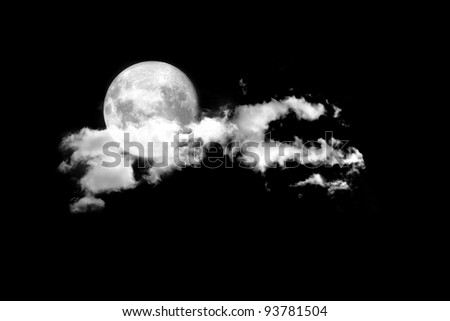 Moon between the clouds in dark night, a dark night brings a bright, amber moon alive with puffy hazy clouds.