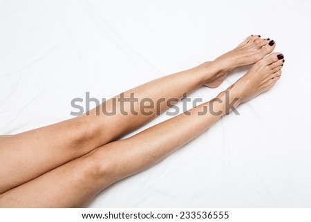 Shaved and smooth woman\'s long legs. Isolated on white