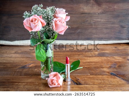 makeup brush and cosmetics on white wooden table