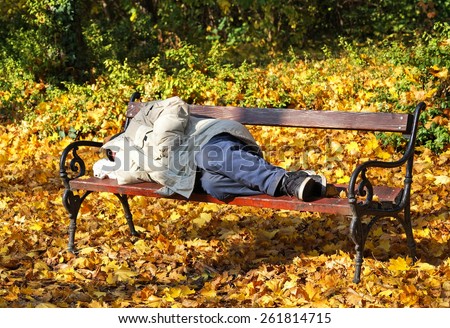 Homeless man is sleeping on a park bench