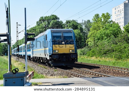 Electric passenger train at the road crossing