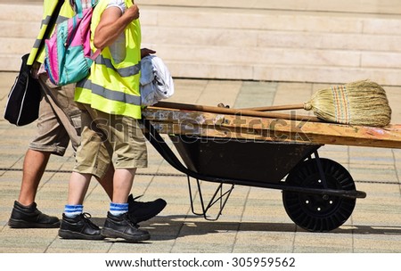 Street cleaners with wheelbarrow and broom