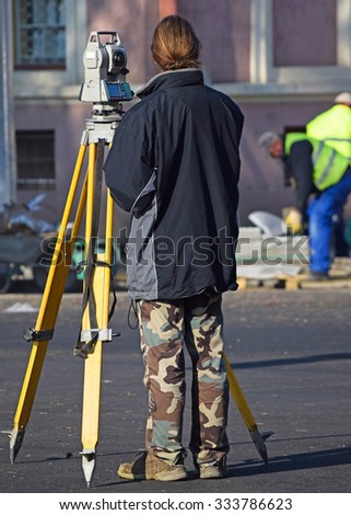 Land surveyor works at the road construction