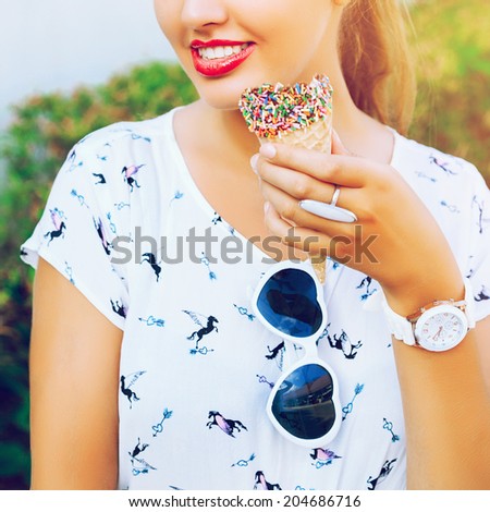 Close up bright image of woman with cone chocolate ice cream, wearing white vintage dress and heart sunglasses, have big smile and full red lips.