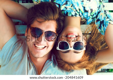 Outdoor fashion portrait of happy smiling couple in love having fun together end enjoy their love and romantic date.