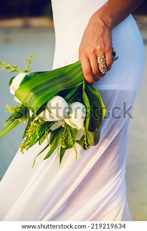 Close up sensual  fashion image ow woman in white dress holding beautiful white lotus bouquet.