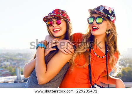 Best friend having fun on the roof, going crazy together, wearing floral swag hats and mirrored sunglasses, amazing view on the city, bright colors evening sunlight.