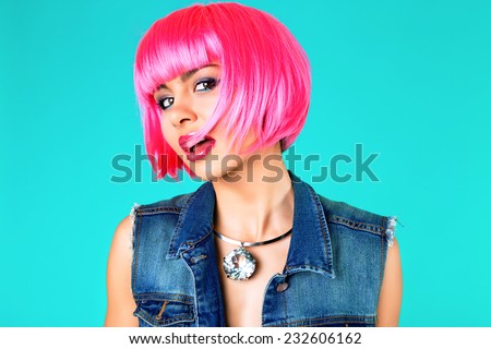 Close up fashion studio portrait of pretty young sensual woman wearing bright make up , neon pink party wig, denim vest and stylish massive diamond necklace.