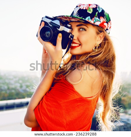Young amazing pretty photographer woman traveling and taking pictures to her retro vintage camera from the roof.