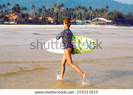 Young sexy fit happy woman running with surf board at California beach, nice sunny day, bright colors.