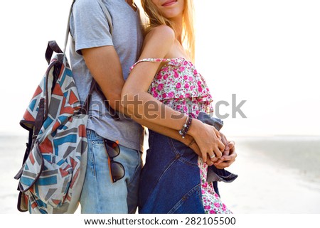 Trendy fashion image of young romantic couple in love wearing stylish hipster vintage clothes, posing at the beach at sunset, love and travel together, positive mood.