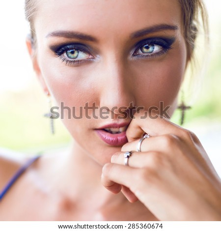 Close up portrait of amazing beautiful woman with bright sexy make up, focus on big green eyes, pastel toned colors.