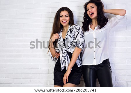 Only emotions. Lovely young girls stylishly dressed in bright  blouse  dark long hair standing at a white wall.