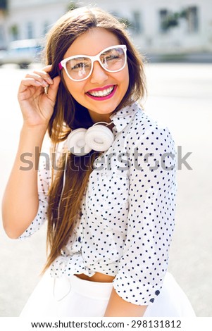 Cute sexy pretty woman wearing fashion white trendy closes, hipster glasses and headphones, having fun alone, big  amazing smile, bright make up ,long hairs, joy, vacation ,happiness.
